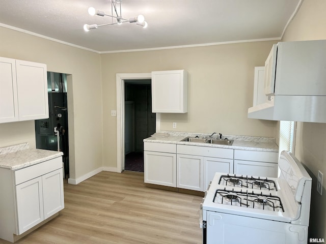 518 Noleman St, Centralia, IL 62801 - kitchen with white range with gas cooktop, a sink, crown molding, light wood-style floors, and white cabinetry