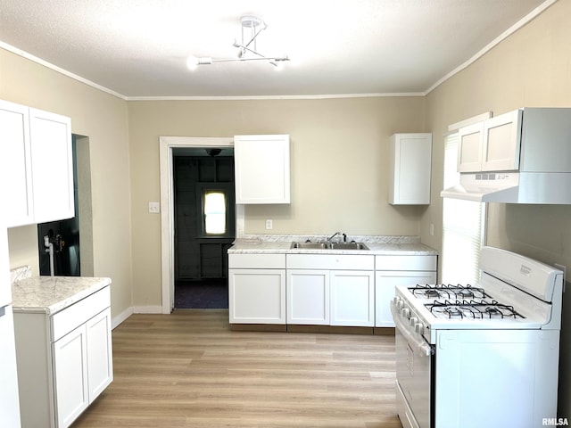 518 Noleman St, Centralia, IL 62801 - kitchen featuring white range with gas cooktop, under cabinet range hood, crown molding, white cabinets, and light wood-style floors