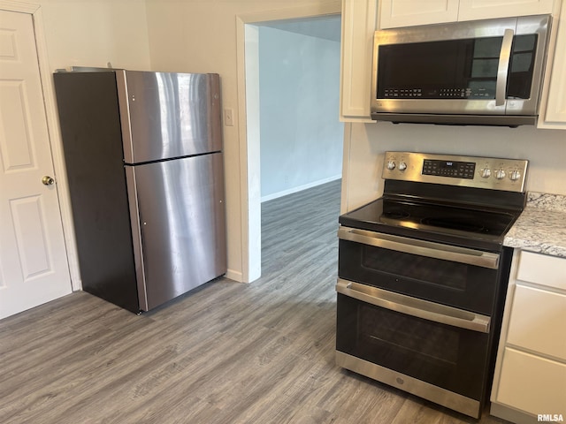 709 S Virginia St, Marion, IL 62959 - kitchen featuring stainless steel appliances, light wood-style flooring, white cabinets, baseboards, and light stone countertops