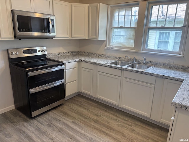 709 S Virginia St, Marion, IL 62959 - kitchen featuring appliances with stainless steel finishes, a sink, white cabinetry, and light wood-style floors