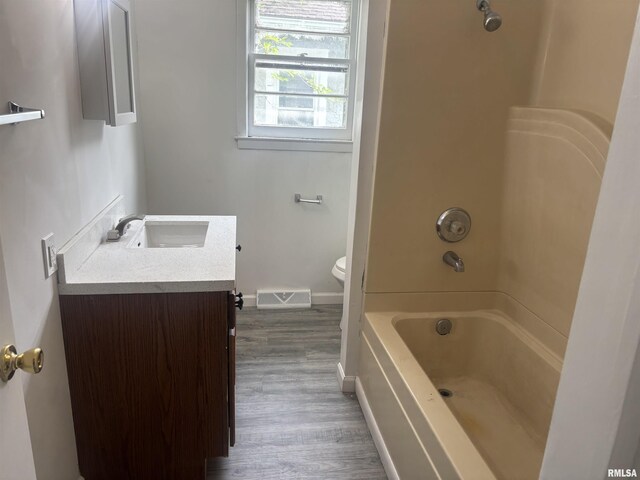 709 S Virginia St, Marion, IL 62959 - bathroom with vanity, wood finished floors, toilet, baseboards, and shower / tub combination