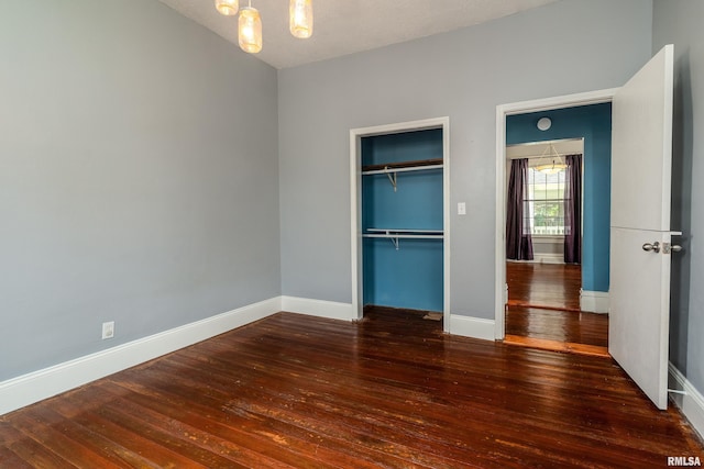 2112 Herbert St, Murphysboro, IL 62966 - unfurnished bedroom featuring hardwood / wood-style floors, baseboards, a chandelier, and a closet