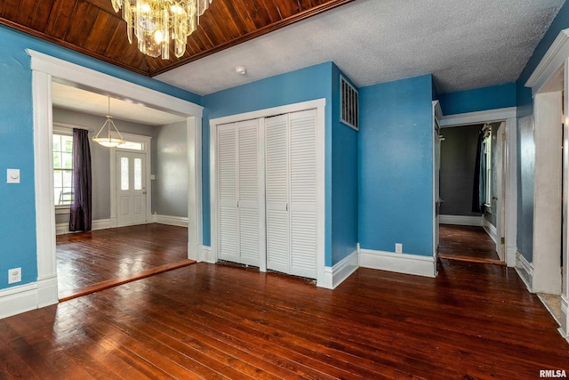 2112 Herbert St, Murphysboro, IL 62966 - unfurnished bedroom featuring wood-type flooring, a chandelier, a closet, and baseboards
