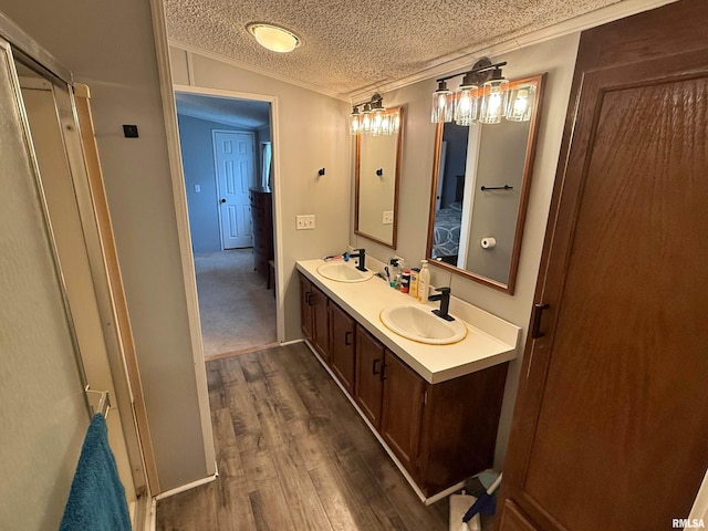 2000 Simmons St, Metropolis, IL 62960 - ensuite bathroom with wood finished floors, double vanity, crown molding, and a textured ceiling