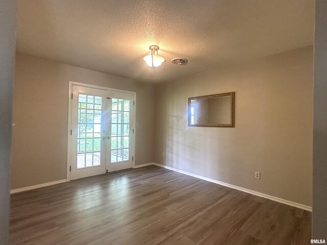 1008 N Norwest Ln, Carbondale, IL 62901 - unfurnished room featuring dark wood finished floors, baseboards, a textured ceiling, and french doors