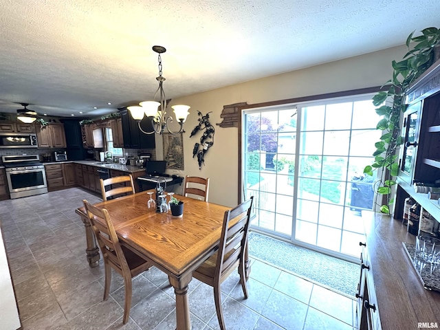 118 W 5th St, Hoffman, IL 62250 - tiled dining space with a chandelier, a textured ceiling, a sink, and a ceiling fan