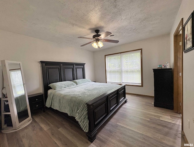 112 Townhouse Dr, Carterville, IL 62918 - bedroom featuring a textured ceiling, light wood-type flooring, and ceiling fan