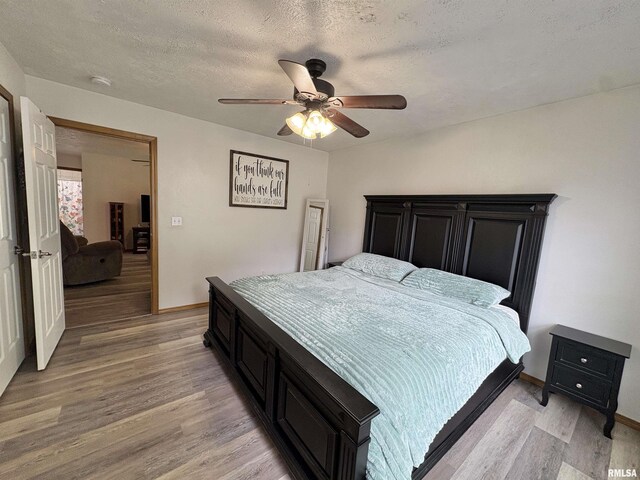 112 Townhouse Dr, Carterville, IL 62918 - bedroom featuring light wood-style flooring, a textured ceiling, baseboards, and ceiling fan
