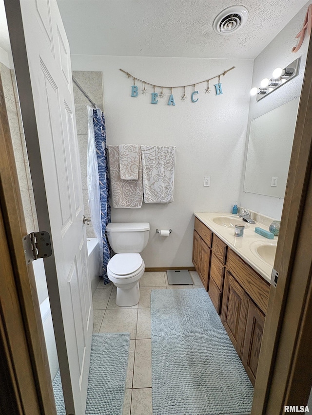 112 Townhouse Dr, Carterville, IL 62918 - full bathroom with double vanity, toilet, a textured ceiling, tile patterned floors, and shower / tub combo with curtain