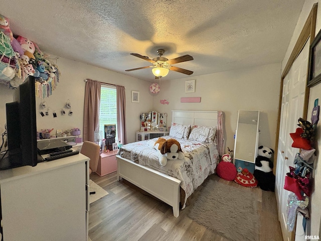 112 Townhouse Dr, Carterville, IL 62918 - bedroom with a textured ceiling, light wood finished floors, and ceiling fan