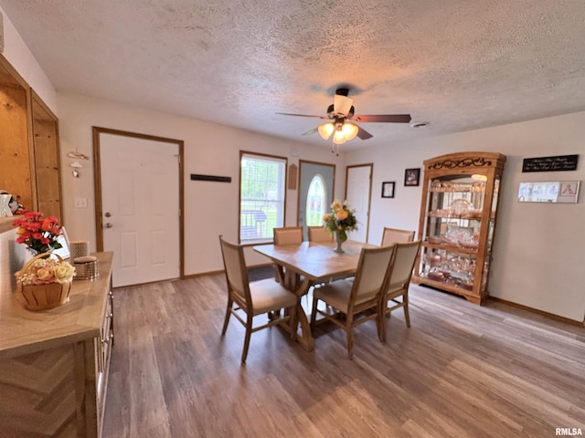 112 Townhouse Dr, Carterville, IL 62918 - dining area with a textured ceiling, light wood finished floors, a ceiling fan, and baseboards