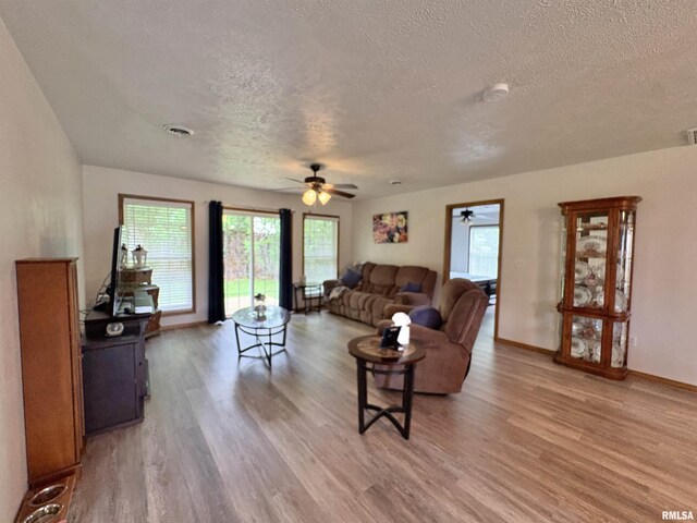 112 Townhouse Dr, Carterville, IL 62918 - living room with a textured ceiling, light wood-style flooring, ceiling fan, and plenty of natural light