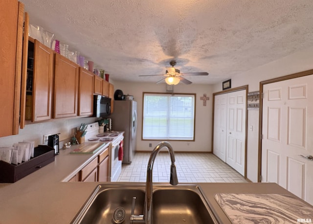 112 Townhouse Dr, Carterville, IL 62918 - kitchen with white electric range oven, black microwave, brown cabinets, ceiling fan, and refrigerator with ice dispenser