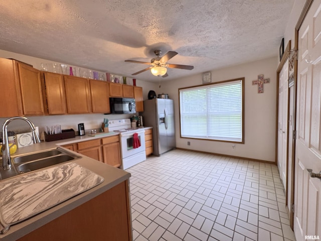 112 Townhouse Dr, Carterville, IL 62918 - kitchen with electric range, black microwave, a sink, stainless steel fridge, and brick patterned floors