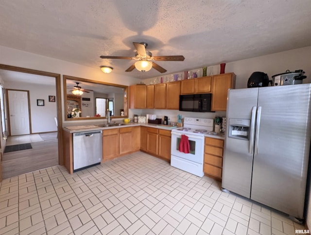 112 Townhouse Dr, Carterville, IL 62918 - kitchen with appliances with stainless steel finishes, ceiling fan, brick patterned floors, light countertops, and a sink