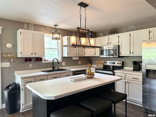 211 E Cross St, Dongola, IL 62926 - kitchen with appliances with stainless steel finishes, a sink, white cabinetry, light countertops, and a textured ceiling