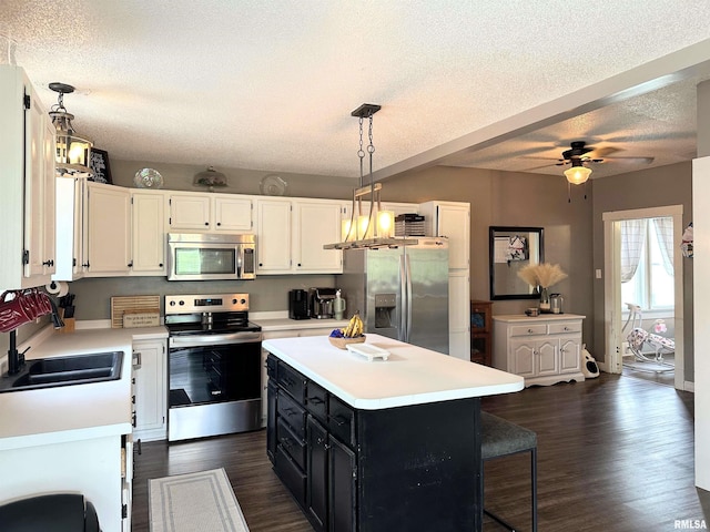 211 E Cross St, Dongola, IL 62926 - kitchen with stainless steel appliances, a sink, dark cabinets, a textured ceiling, and light countertops