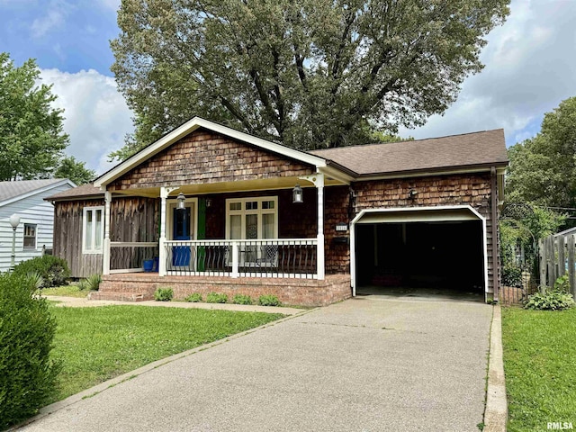 2016 Greenview St, Metropolis, IL 62960 - view of front facade with covered porch, an attached garage, concrete driveway, a front yard, and roof with shingles