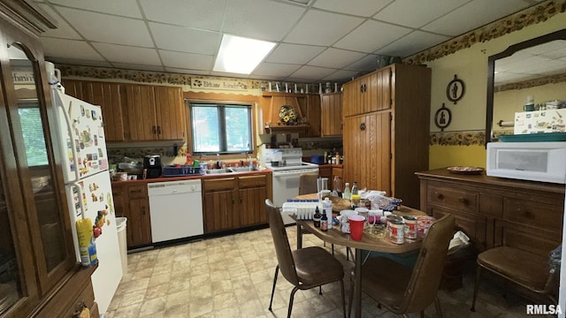 11218 Old Lake Rd, Benton, IL 62812 - kitchen with white appliances, a paneled ceiling, a sink, tile countertops, and brown cabinetry