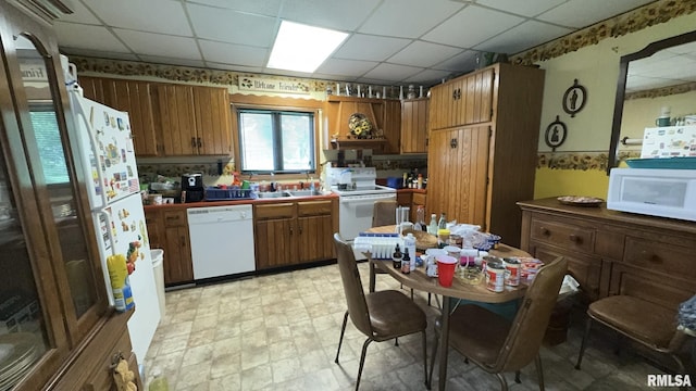 11218 Old Lake Rd, Benton, IL 62812 - kitchen with white appliances, a drop ceiling, brown cabinets, a sink, and tile counters