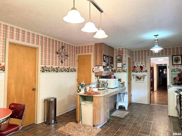 1011 W Goodall St, Marion, IL 62959 - kitchen with wallpapered walls, a textured ceiling, brick patterned flooring, light countertops, and wainscoting