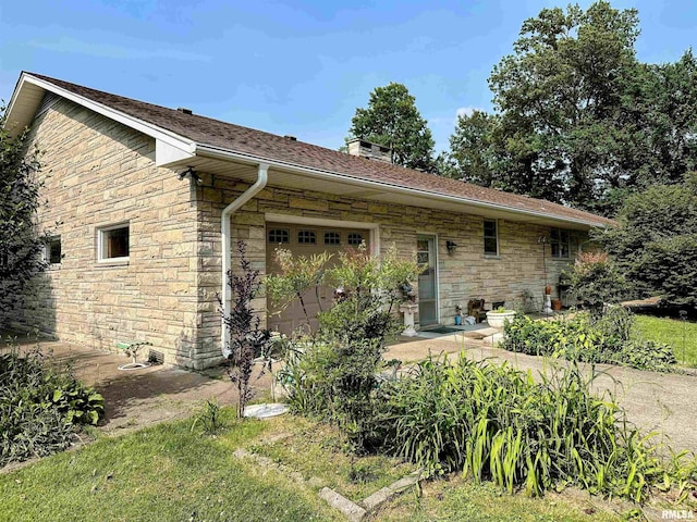 1011 W Goodall St, Marion, IL 62959 - back of house with stone siding, a garage, a chimney, and a shingled roof