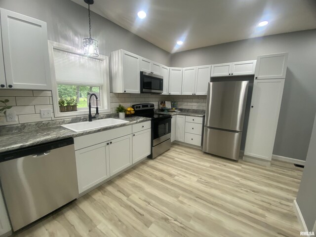 421 N 10th St, Benton, IL 62812 - kitchen with appliances with stainless steel finishes, a sink, backsplash, light wood finished floors, and pendant lighting