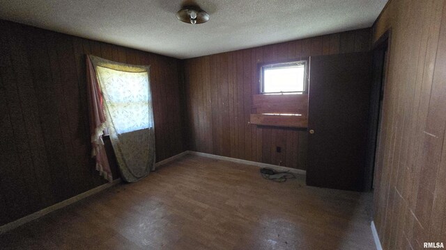 101 Diamond St, Mound City, IL 62963 - unfurnished room featuring wood finished floors, wood walls, a textured ceiling, and baseboards