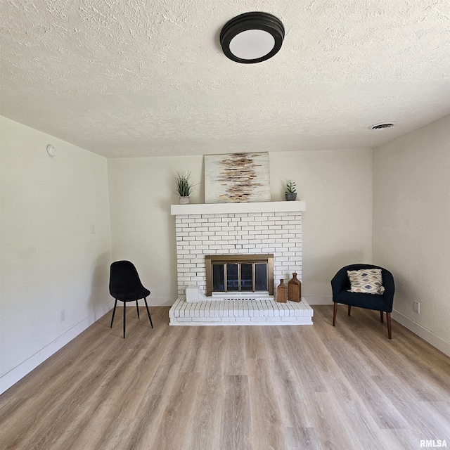 15074 N Mccauley Ln, Mount Vernon, IL 62864 - living area featuring a textured ceiling, wood finished floors, a fireplace, and baseboards