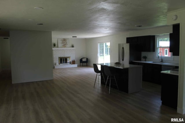 15074 N Mccauley Ln, Mount Vernon, IL 62864 - kitchen with a sink, a center island, a breakfast bar, wood finished floors, and light countertops