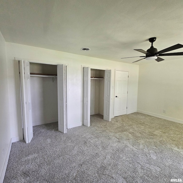15074 N Mccauley Ln, Mount Vernon, IL 62864 - unfurnished bedroom featuring two closets, carpet floors, baseboards, and a ceiling fan