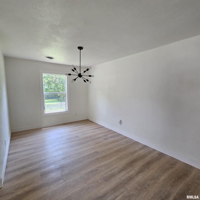 15074 N Mccauley Ln, Mount Vernon, IL 62864 - empty room featuring a chandelier, wood finished floors, and baseboards