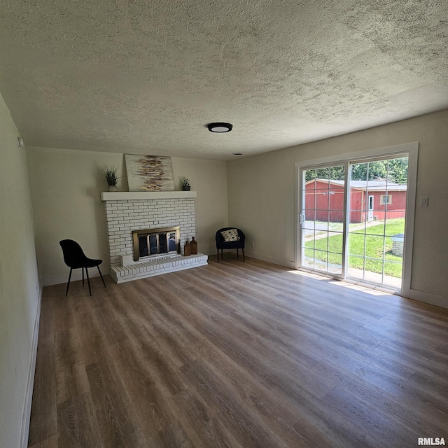 15074 N Mccauley Ln, Mount Vernon, IL 62864 - unfurnished living room with a textured ceiling, wood finished floors, a fireplace, and baseboards