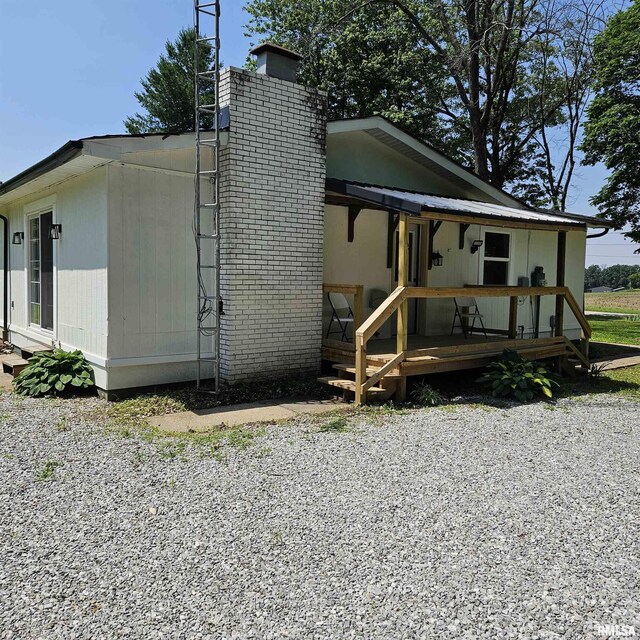 15074 N Mccauley Ln, Mount Vernon, IL 62864 - view of property exterior with a chimney and covered porch