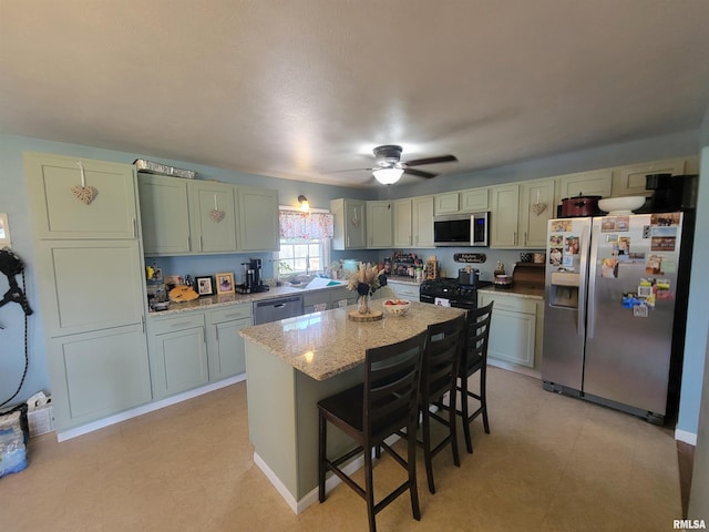 100 Stable Dr, Carterville, IL 62918 - kitchen with appliances with stainless steel finishes, ceiling fan, a breakfast bar, a center island, and light stone counters