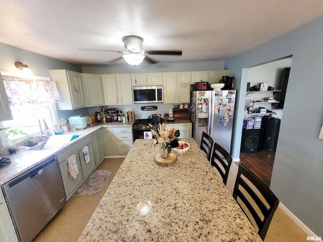 100 Stable Dr, Carterville, IL 62918 - kitchen featuring appliances with stainless steel finishes, a sink, light stone countertops, and a ceiling fan