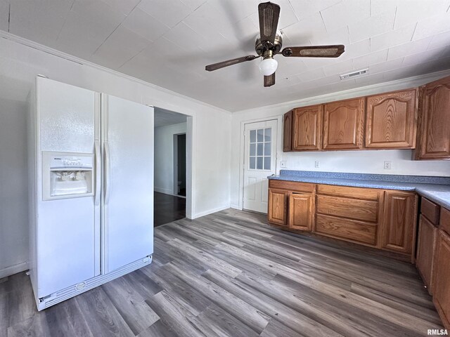 329 N Broadway Ave, Goreville, IL 62939 - kitchen with white fridge with ice dispenser, ceiling fan, brown cabinets, wood finished floors, and baseboards
