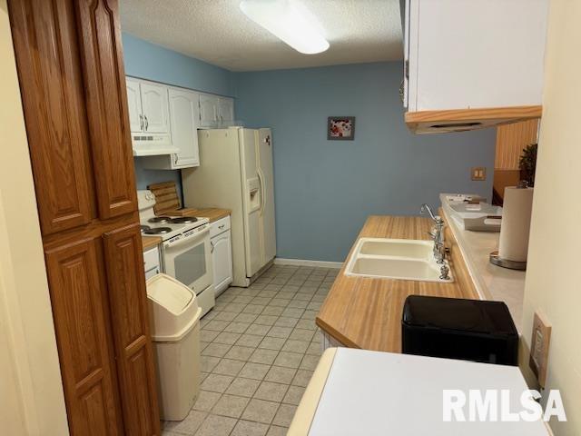 1700 W Taylor Dr, Carbondale, IL 62901 - kitchen with a sink, under cabinet range hood, white appliances, a textured ceiling, and light countertops