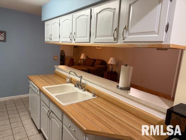 1700 W Taylor Dr, Carbondale, IL 62901 - kitchen featuring dishwasher, a sink, white cabinets, and light countertops