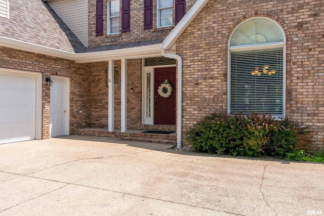 1803 N Dawn Dr, Marion, IL 62959 - view of exterior entry with brick siding, concrete driveway, roof with shingles, covered porch, and an attached garage