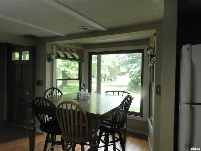 4370 Buncombe Rd, Vienna, IL 62995 - dining space featuring wood finished floors, healthy amount of natural light, and a textured ceiling