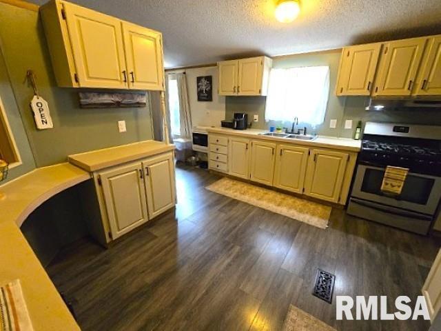 18802 E Fairfield Rd, Mount Vernon, IL 62864 - kitchen with stainless steel range with gas cooktop, light countertops, a textured ceiling, dark wood finished floors, and extractor fan