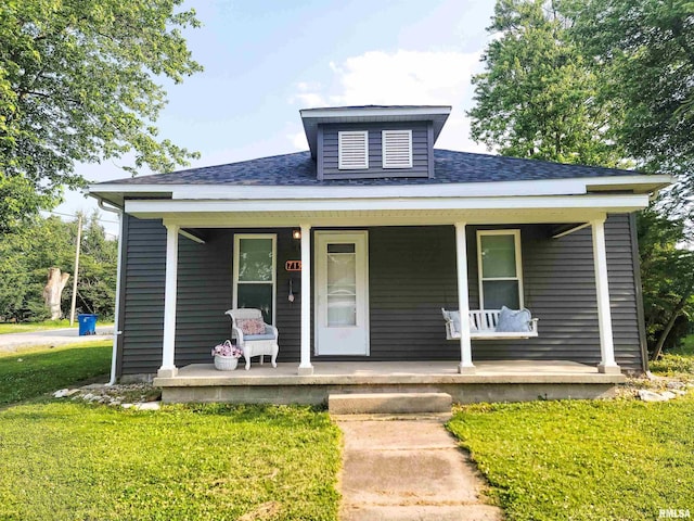 719 E Cherry St, Olney, IL 62450 - bungalow-style house with a porch, a front lawn, and roof with shingles