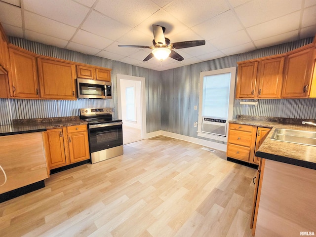 719 E Cherry St, Olney, IL 62450 - kitchen featuring appliances with stainless steel finishes, a drop ceiling, light wood-type flooring, ceiling fan, and brown cabinetry