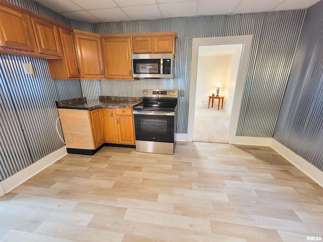 719 E Cherry St, Olney, IL 62450 - kitchen featuring appliances with stainless steel finishes, a drop ceiling, wallpapered walls, light wood finished floors, and dark countertops