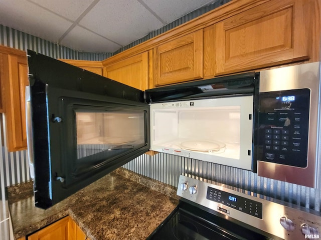 719 E Cherry St, Olney, IL 62450 - kitchen view of range, a paneled ceiling, and brown cabinets