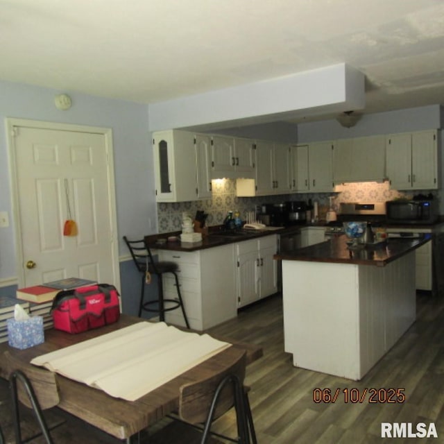 632 N Pershing St, Energy, IL 62933 - kitchen featuring dark countertops, backsplash, black microwave, and dark wood-style flooring