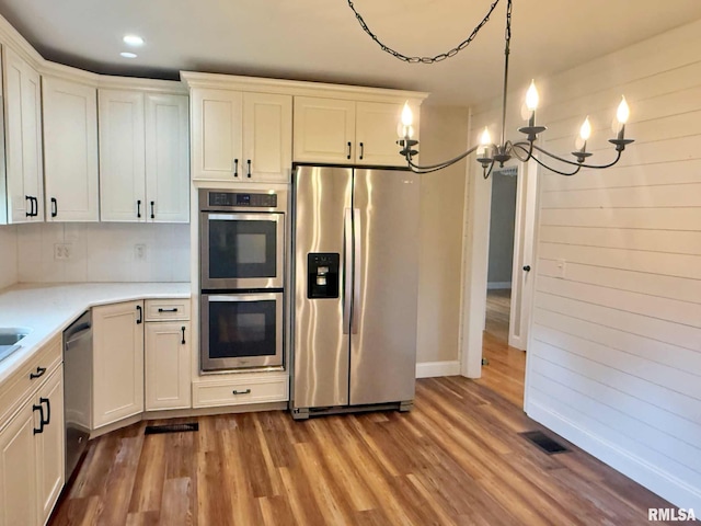 2223 N Ave, Metropolis, IL 62960 - kitchen with appliances with stainless steel finishes, a chandelier, wood finished floors, light countertops, and recessed lighting