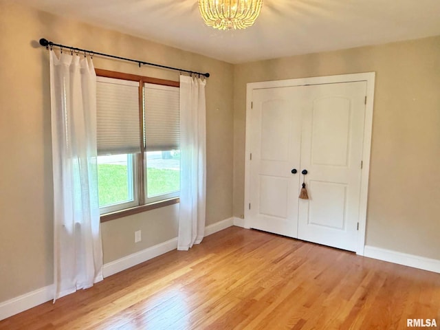 2223 N Ave, Metropolis, IL 62960 - unfurnished bedroom with a chandelier, light wood-type flooring, and a closet