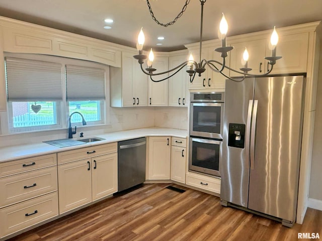 2223 N Ave, Metropolis, IL 62960 - kitchen featuring stainless steel appliances, light countertops, dark wood finished floors, tasteful backsplash, and hanging light fixtures